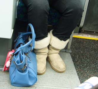 legs with boots and a blue purse on a train