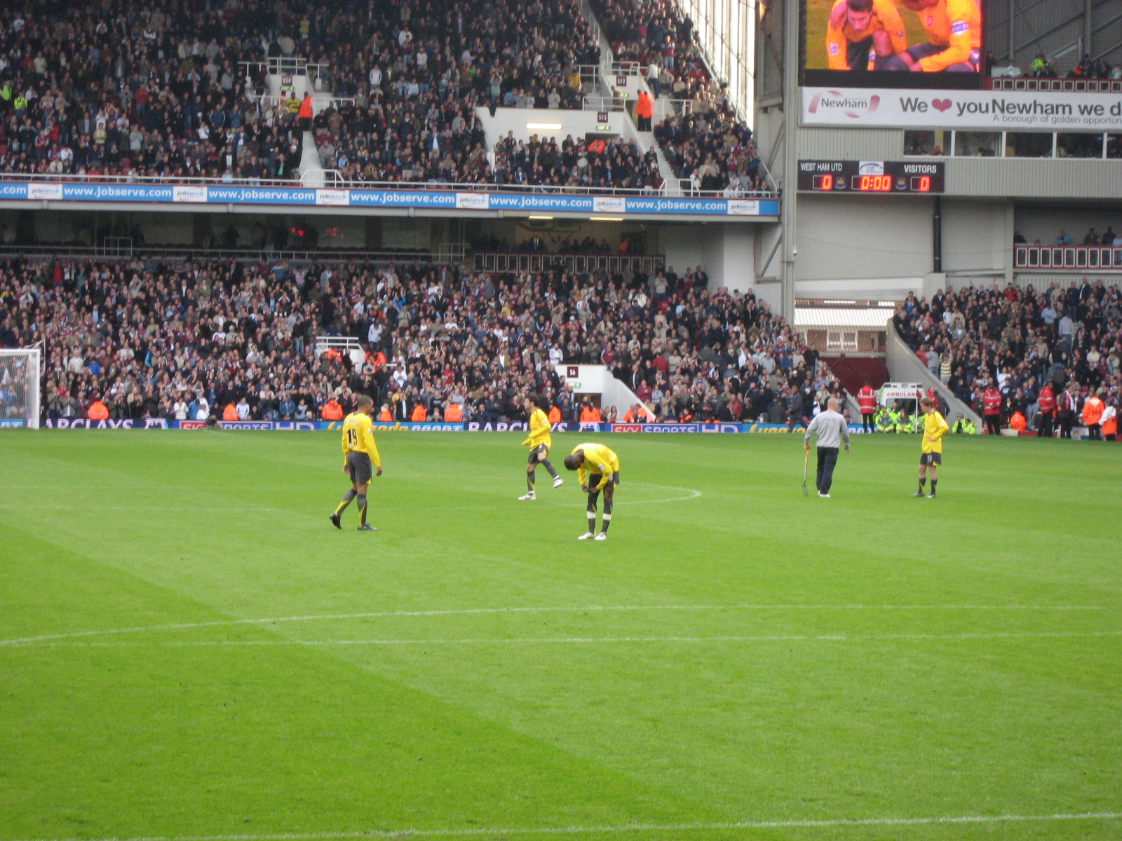 several soccer players stand on a field and watch as the crowd is watching