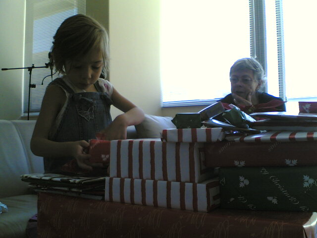 small girl checking out a stack of holiday gifts