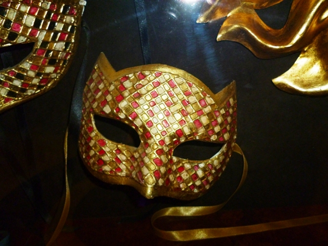 a colorful mask with gold chains and a metal mask