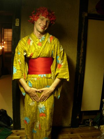 a man dressed in a yellow kimono and smiling