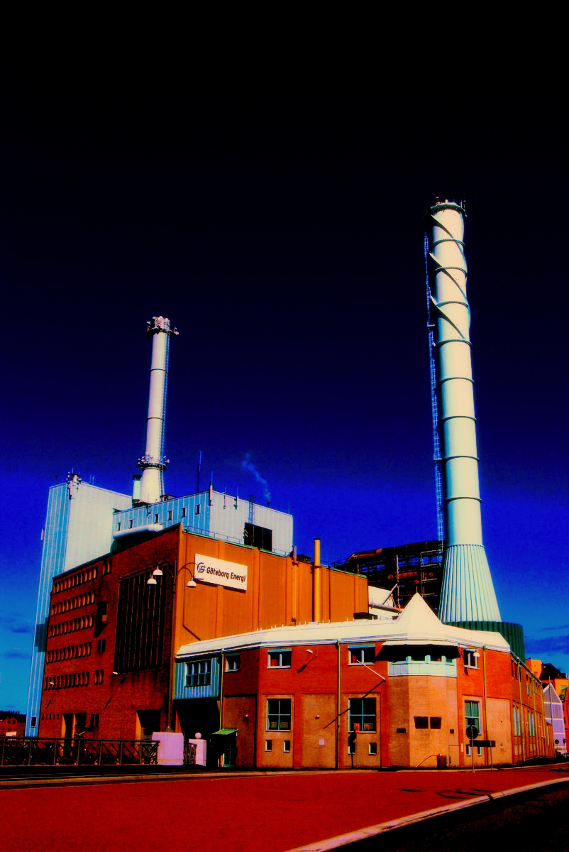 a red brick factory with smoke stacks