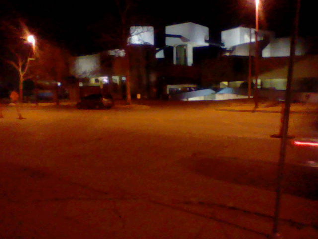 night image in suburban area, showing buildings and parking spaces