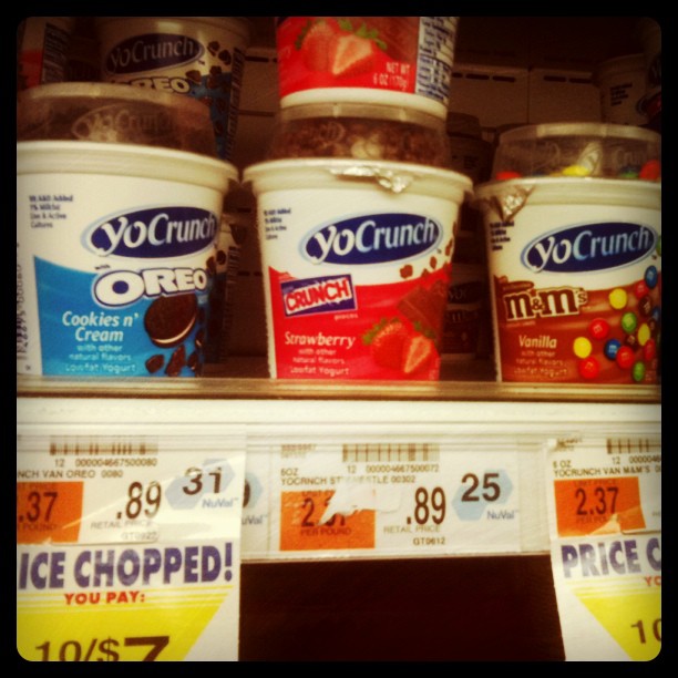 yogurt and chocolate ding in plastic tubs are seen on the shelves at a store