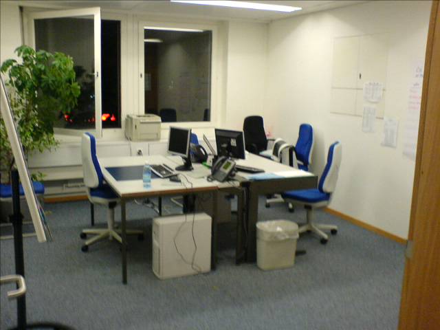 an office cubicle has desks and chairs around it