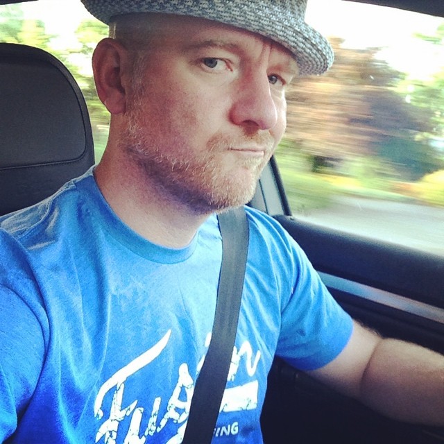 man wearing hat while sitting in back seat of car