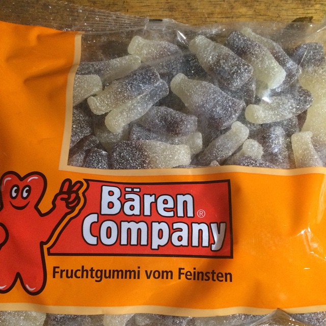 a bag of frozen white candies with a large candy bear sitting on it