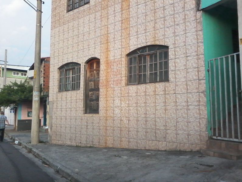 a man walks in front of the brown wall and doors