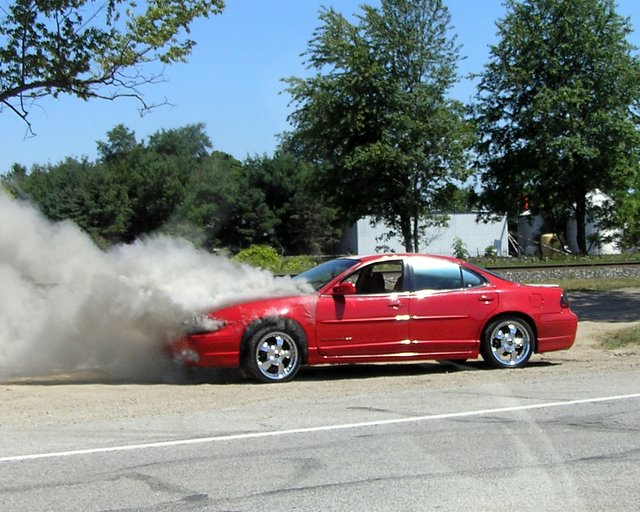 a red car has smoke from it, making the top sparkle