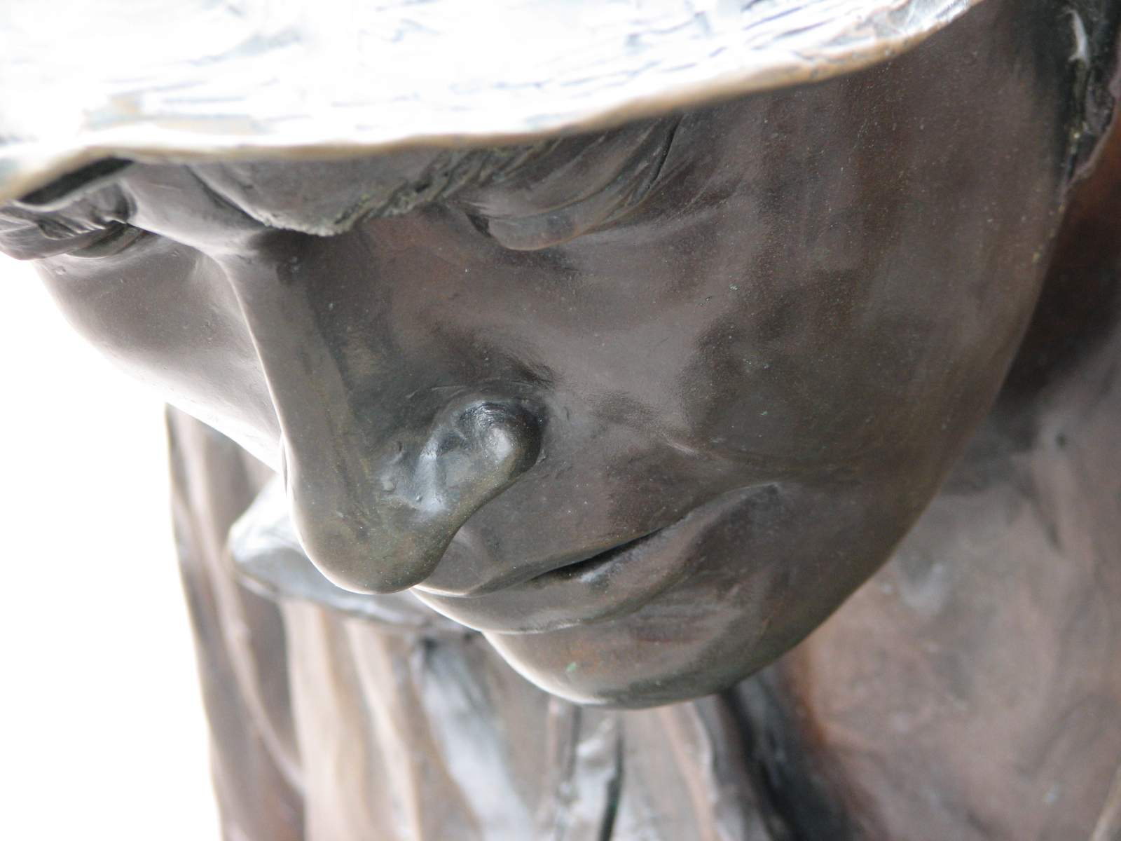 a bronze statue with an opened mouth and hat