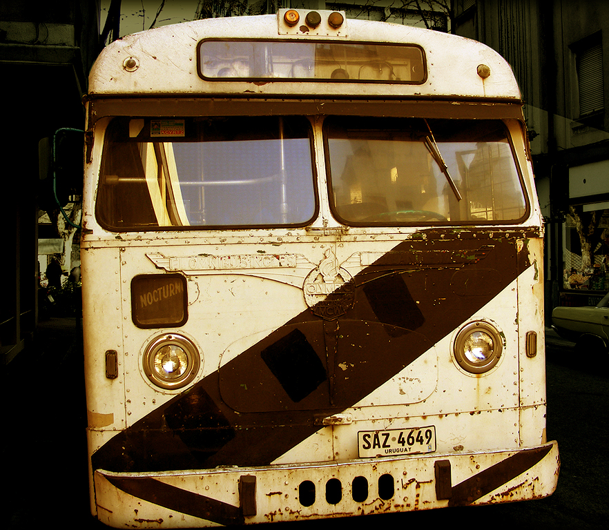 an old bus parked next to the side of a building