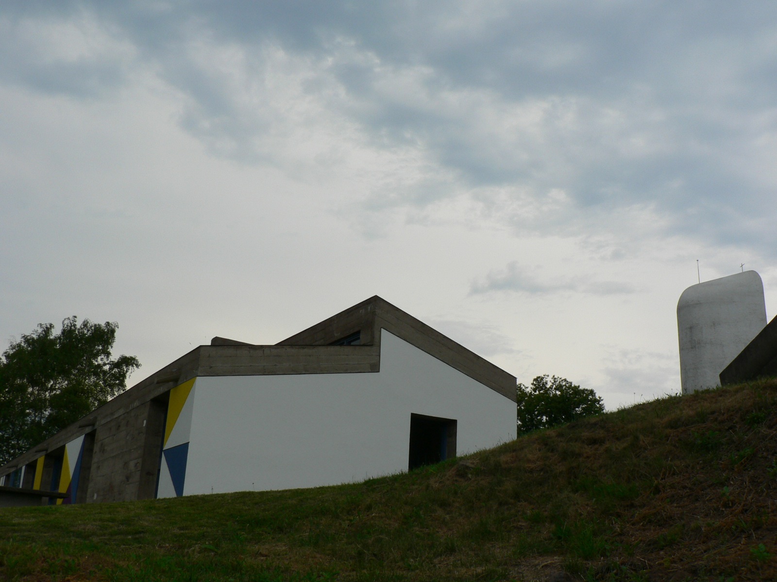 a picture of a structure next to a silo on the hill