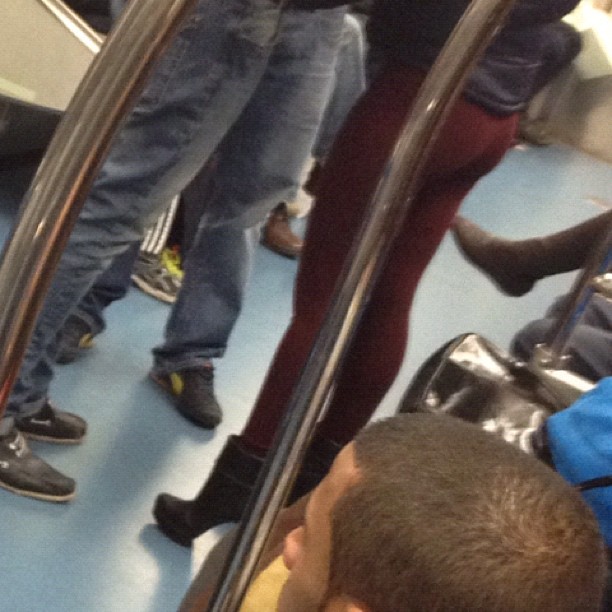 two people standing on a subway next to each other