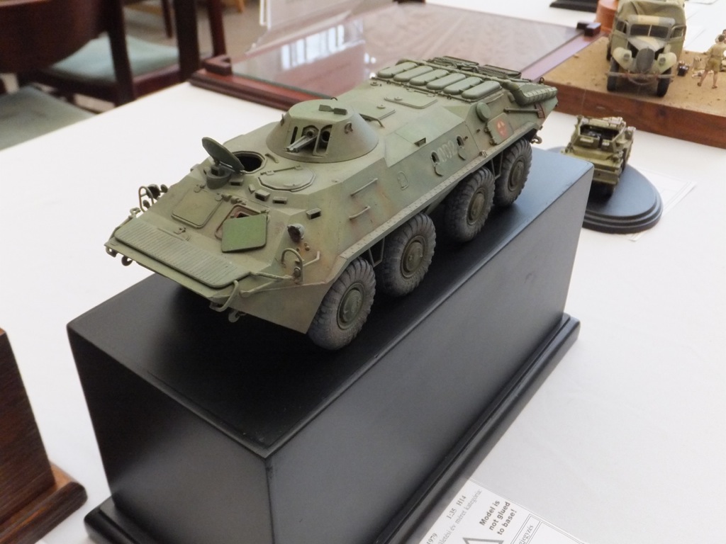 a toy soldier armored vehicle is on a black display shelf