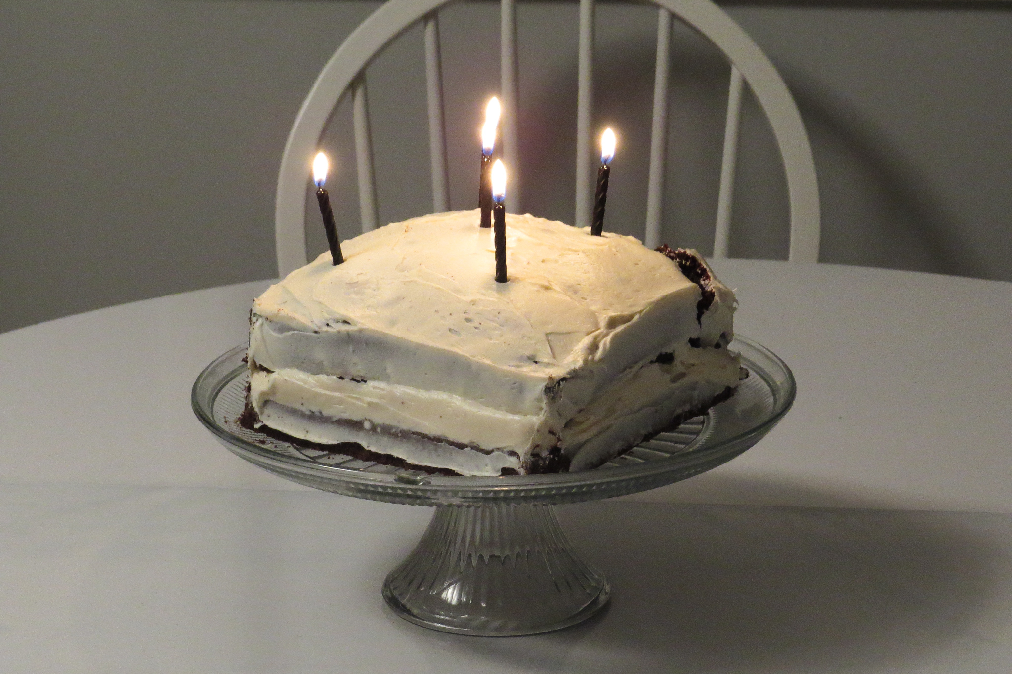an image of a cake on a table with three lit candles