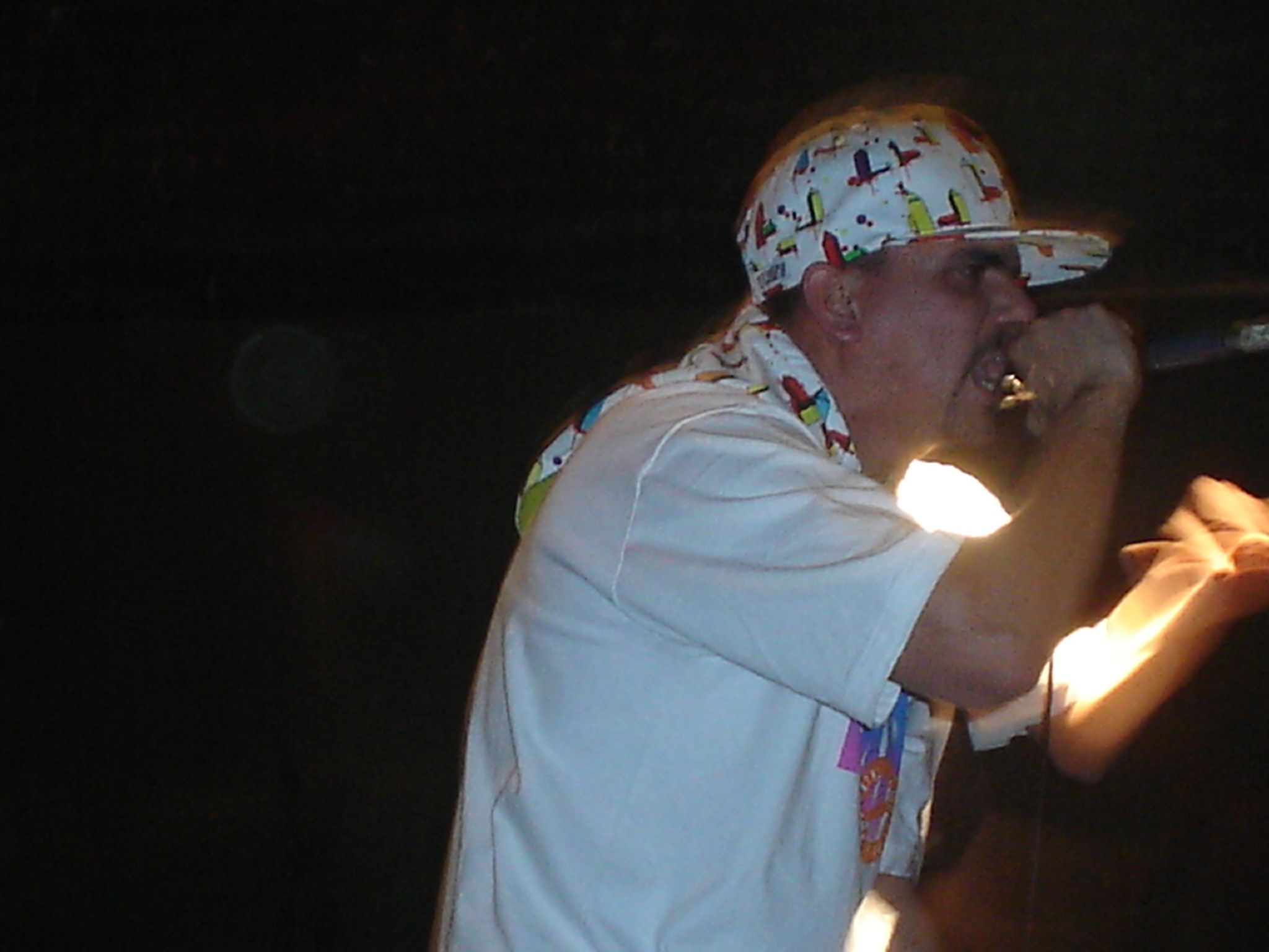 a man wearing a bandana singing into a microphone