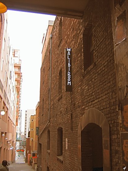 the alleyway is narrow and the people are walking