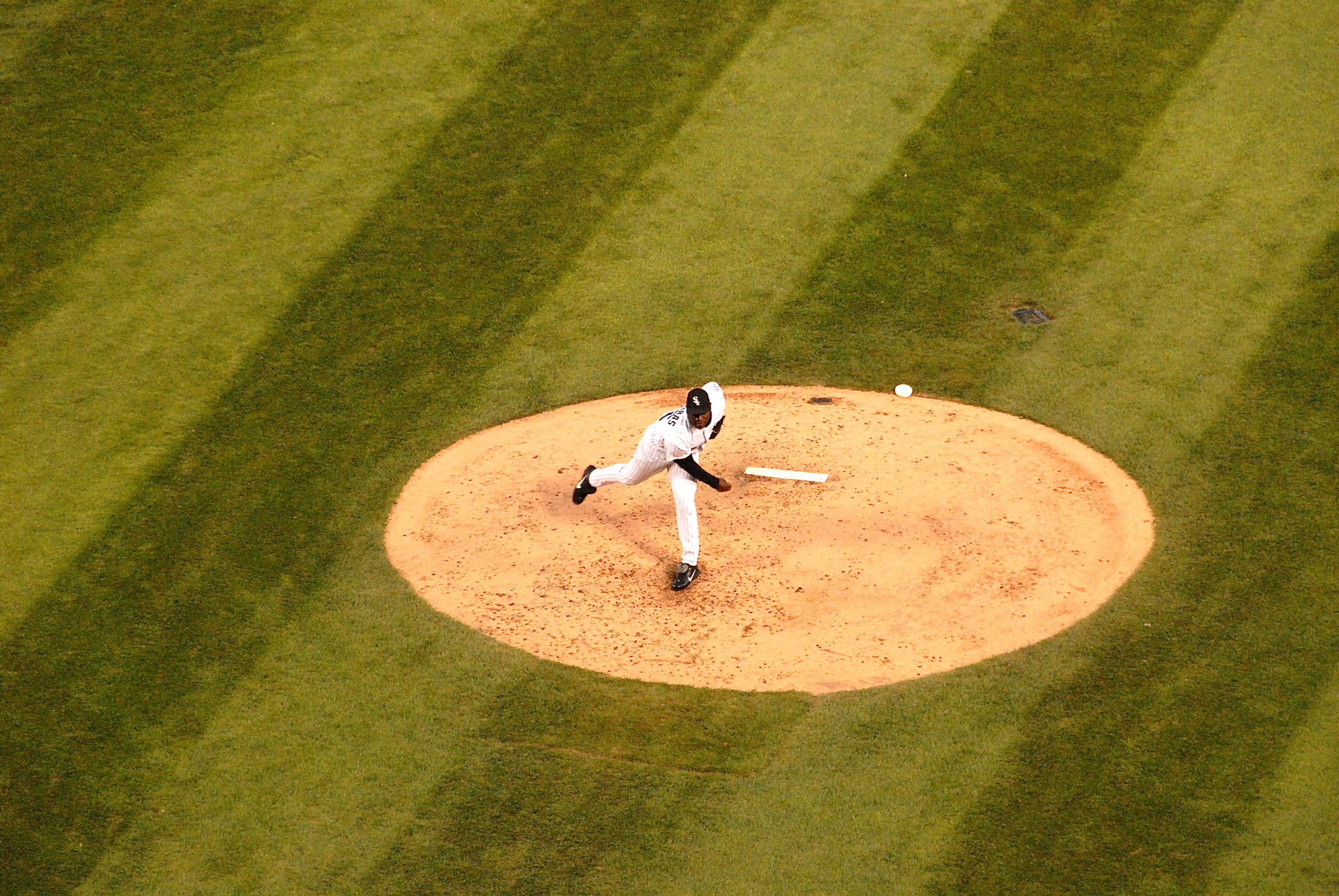 a baseball pitcher throwing a ball from a mound