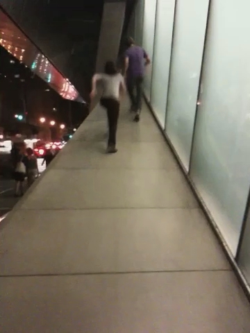 a pair of men walking down a sidewalk together