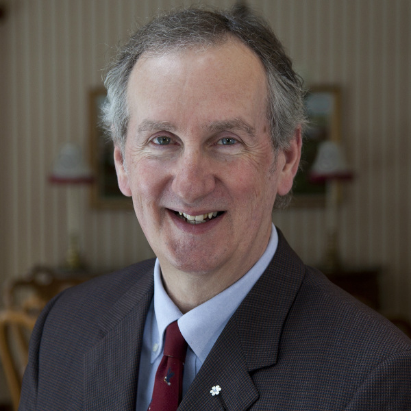 a smiling middle aged man wearing a suit and tie