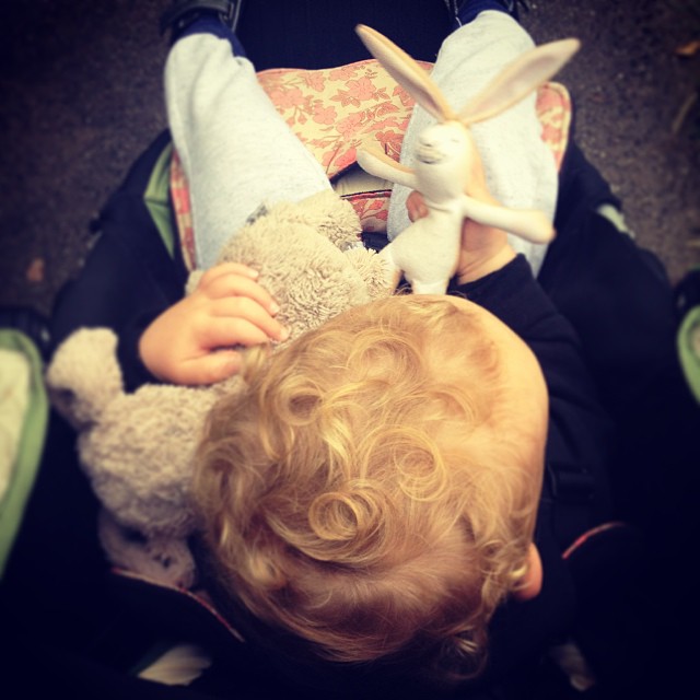 a little child is laying down playing with stuffed animals