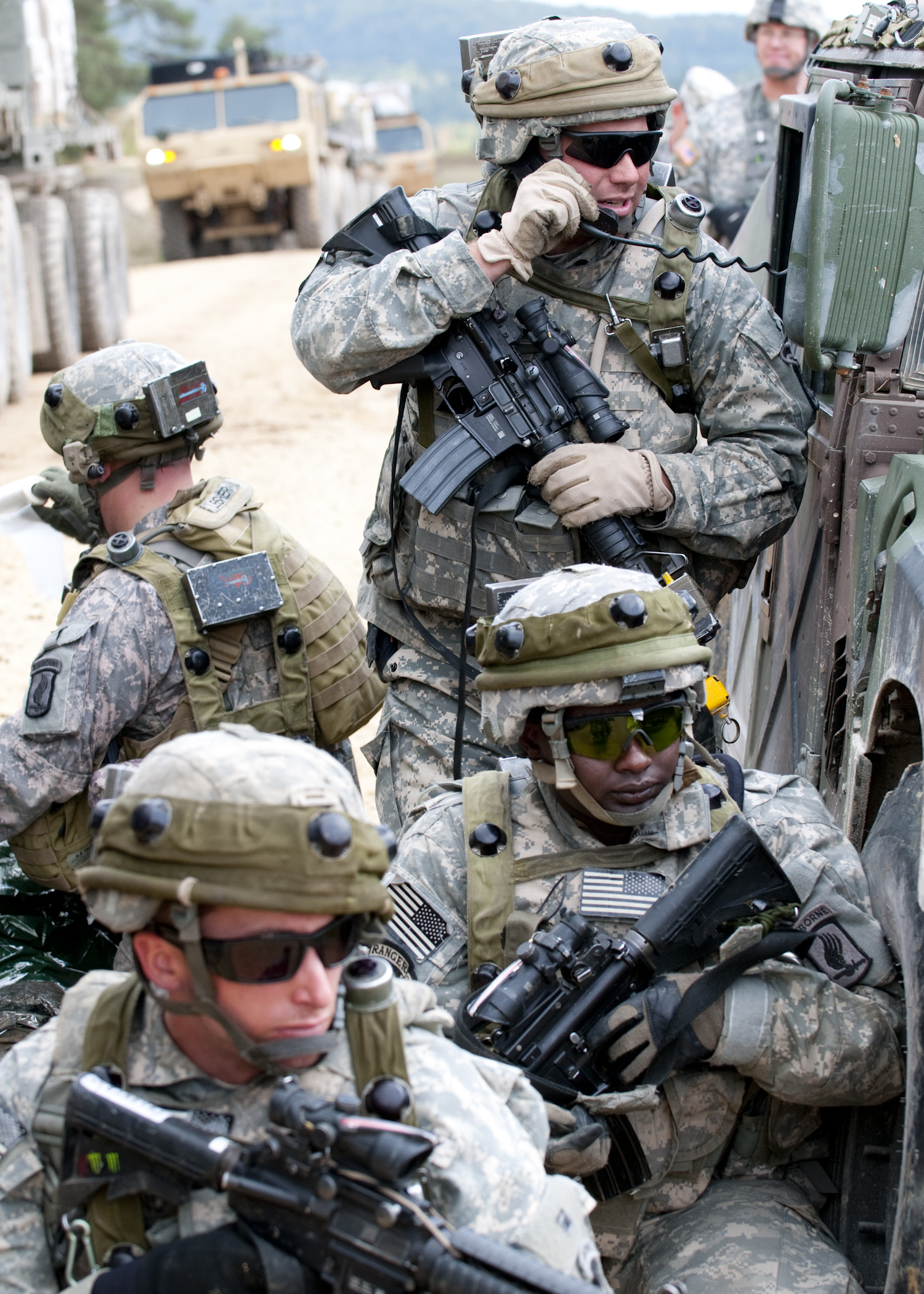 soldiers in uniform near an armored vehicle and soldier