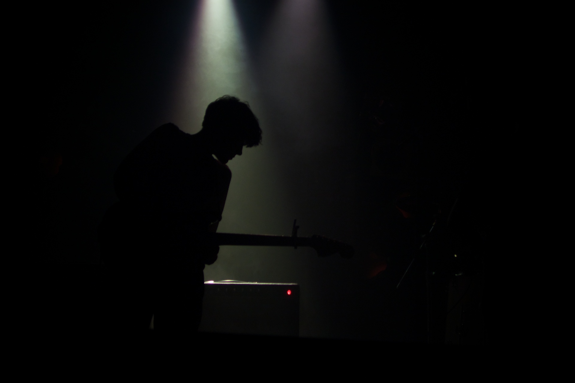 a person playing with a guitar while surrounded by lights