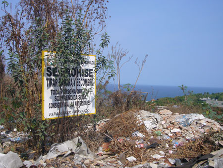 a sign on a metal pole in front of some trash and debris