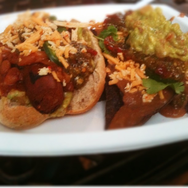 this is two  dogs with condiments on a plate