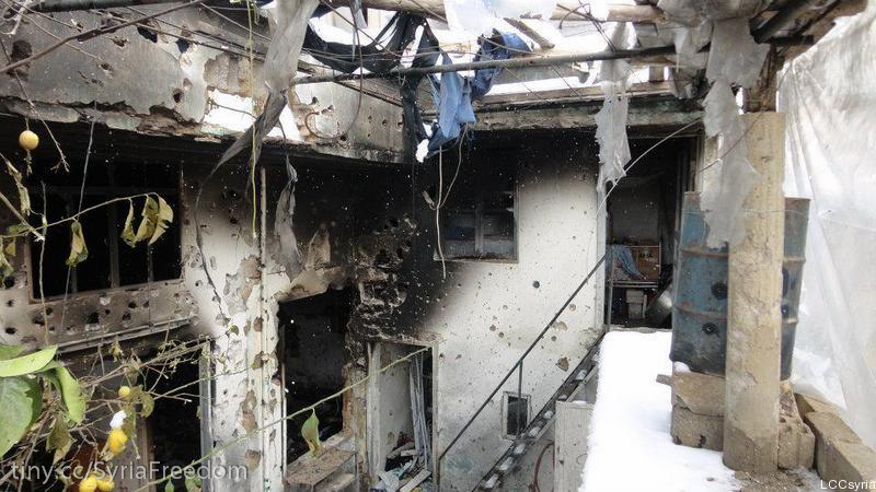 a burned building with only some nches and the door partially open