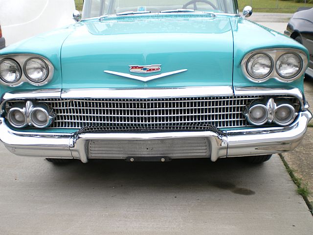 an old green car with chrome hood and headlights