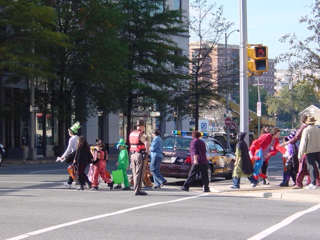 a group of people crossing the street in front of cars