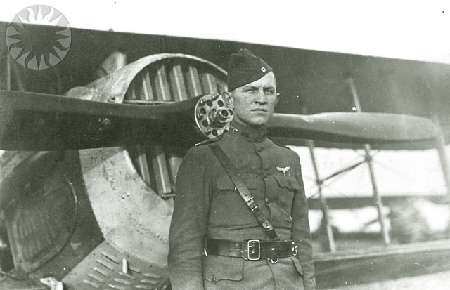 a man in uniform standing in front of an airplane
