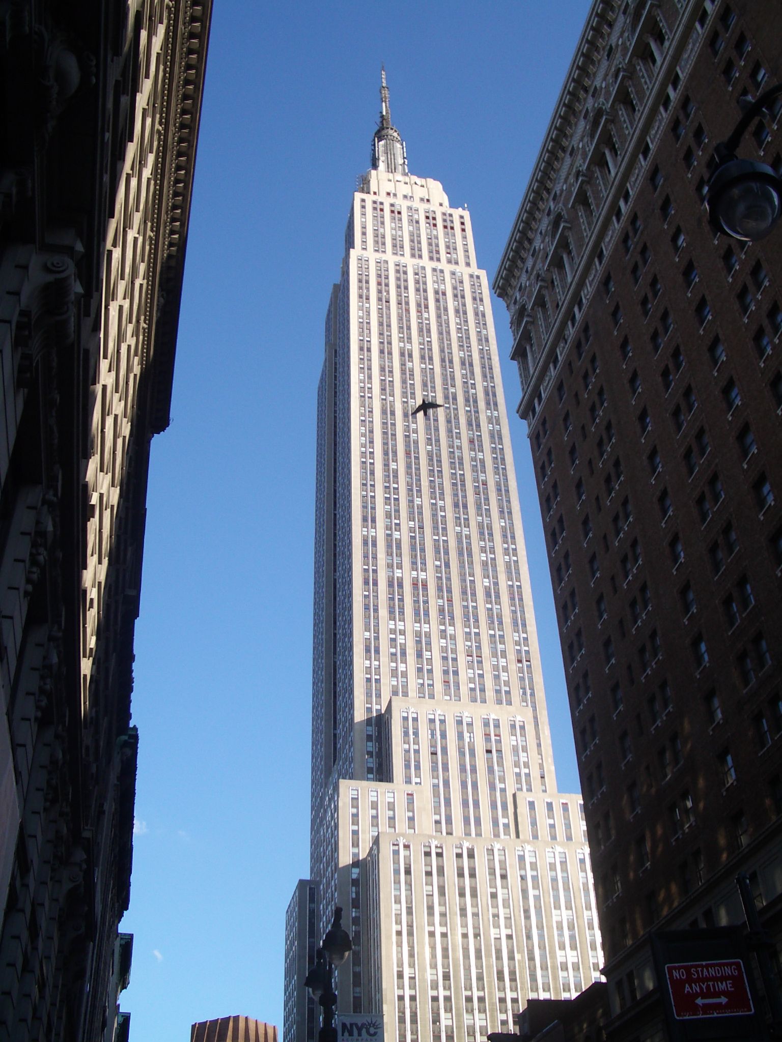 an airplane flying in front of tall buildings