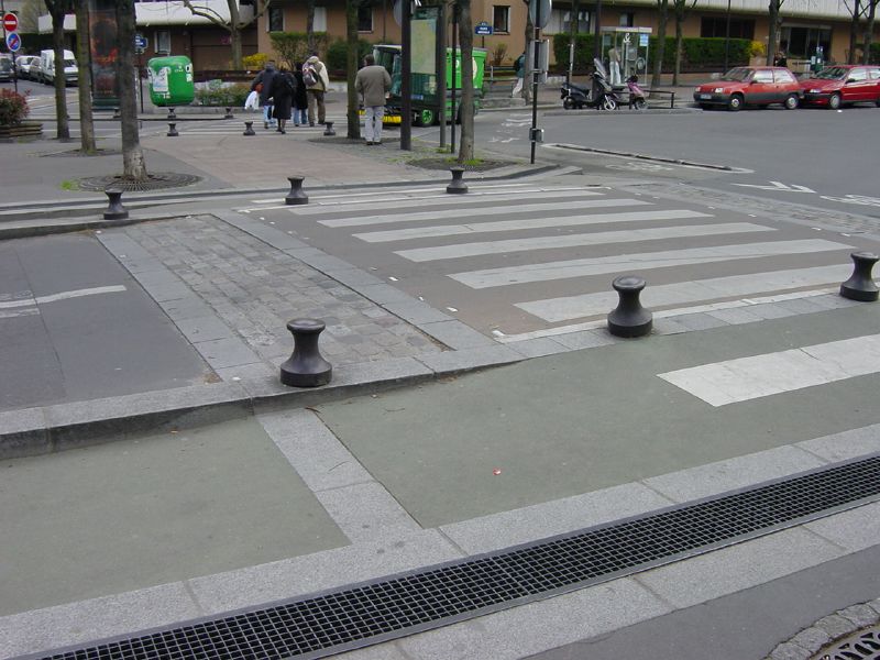 a cross walk in a small town surrounded by tall buildings