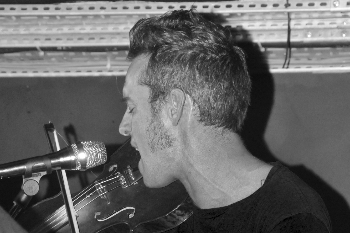 a man playing violin by a microphone