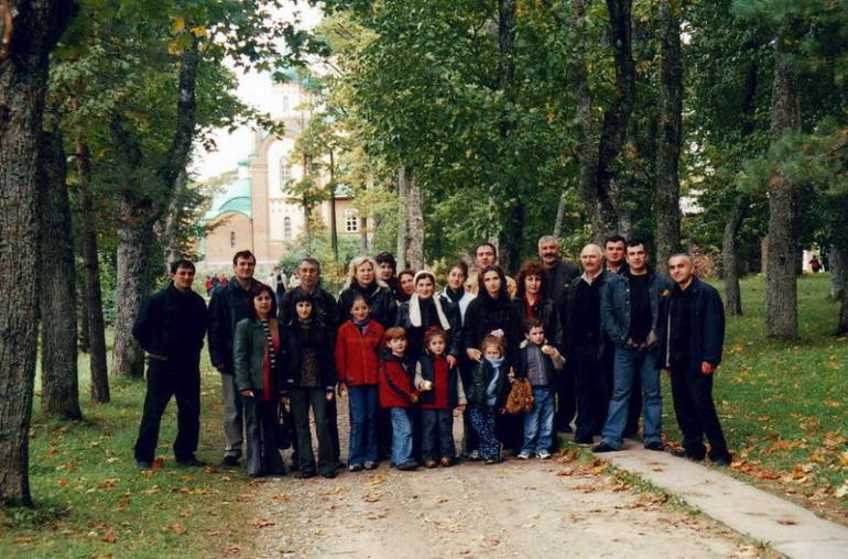 a group of people stand outside in the trees