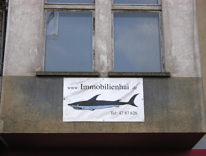 a sign on the side of a large gray building