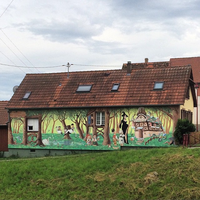 some painted houses with trees in the yard