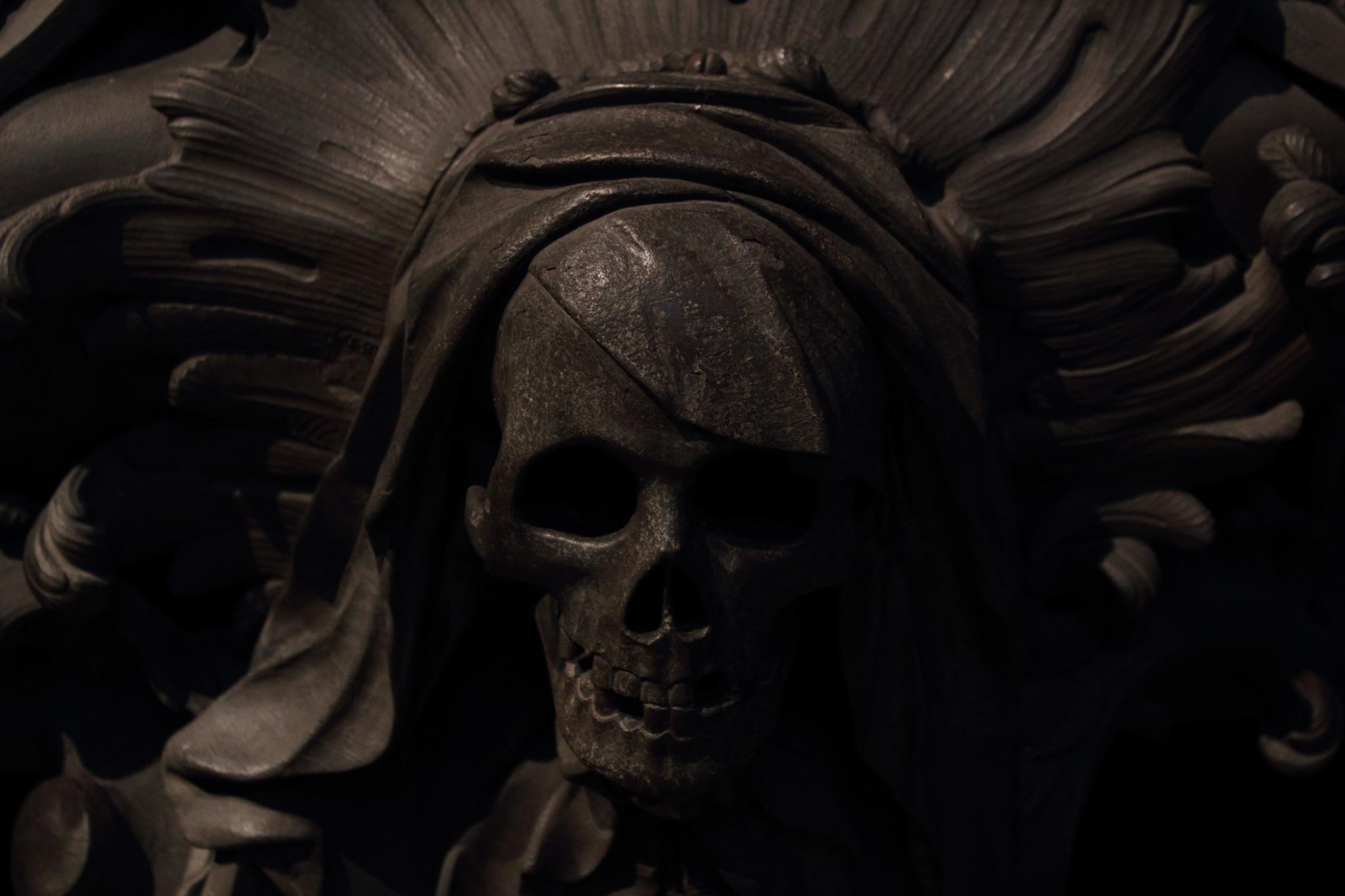 the skeleton is wearing a headdress in the dark