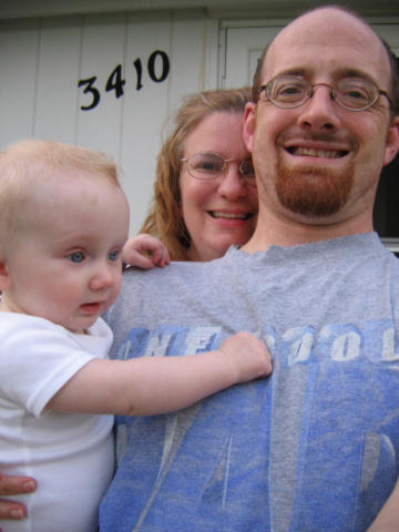 a man and woman holding a baby boy