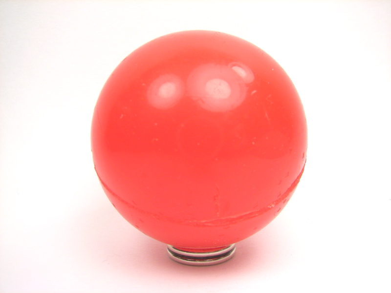 a red ball on a black object with no background