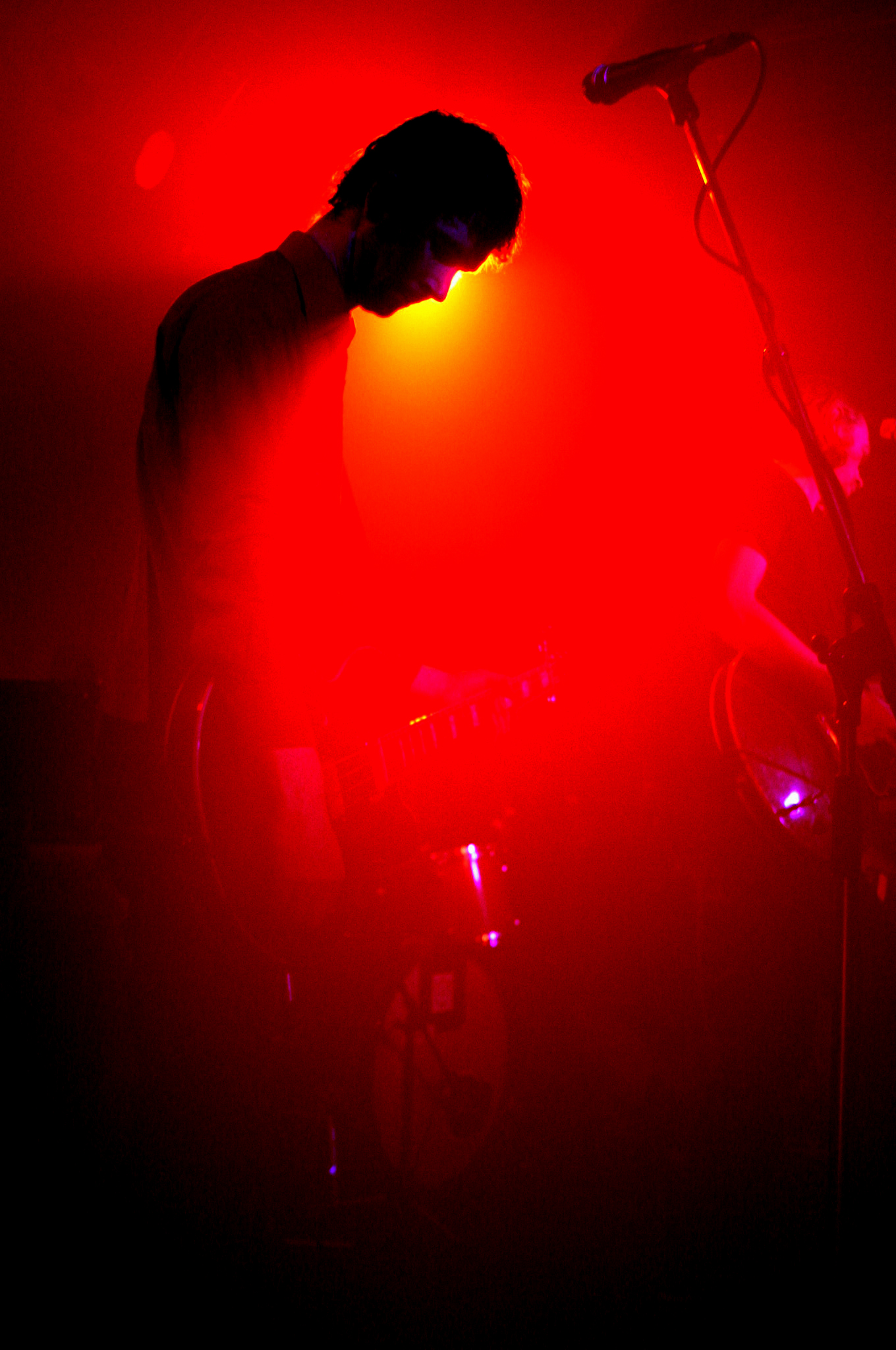 a person standing at a microphone with a red light