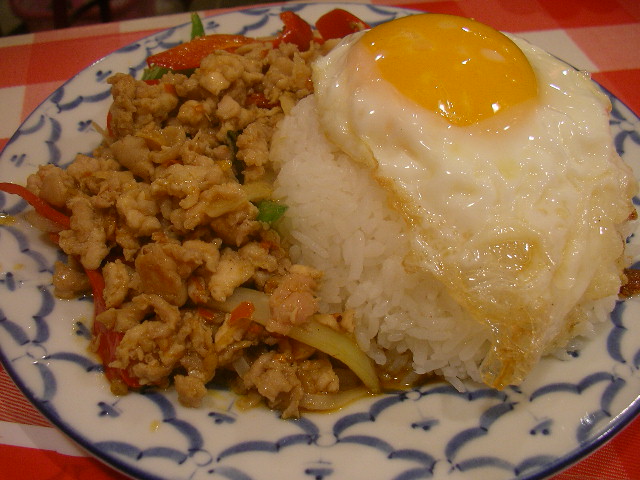 fried eggs are cooked over rice with chicken