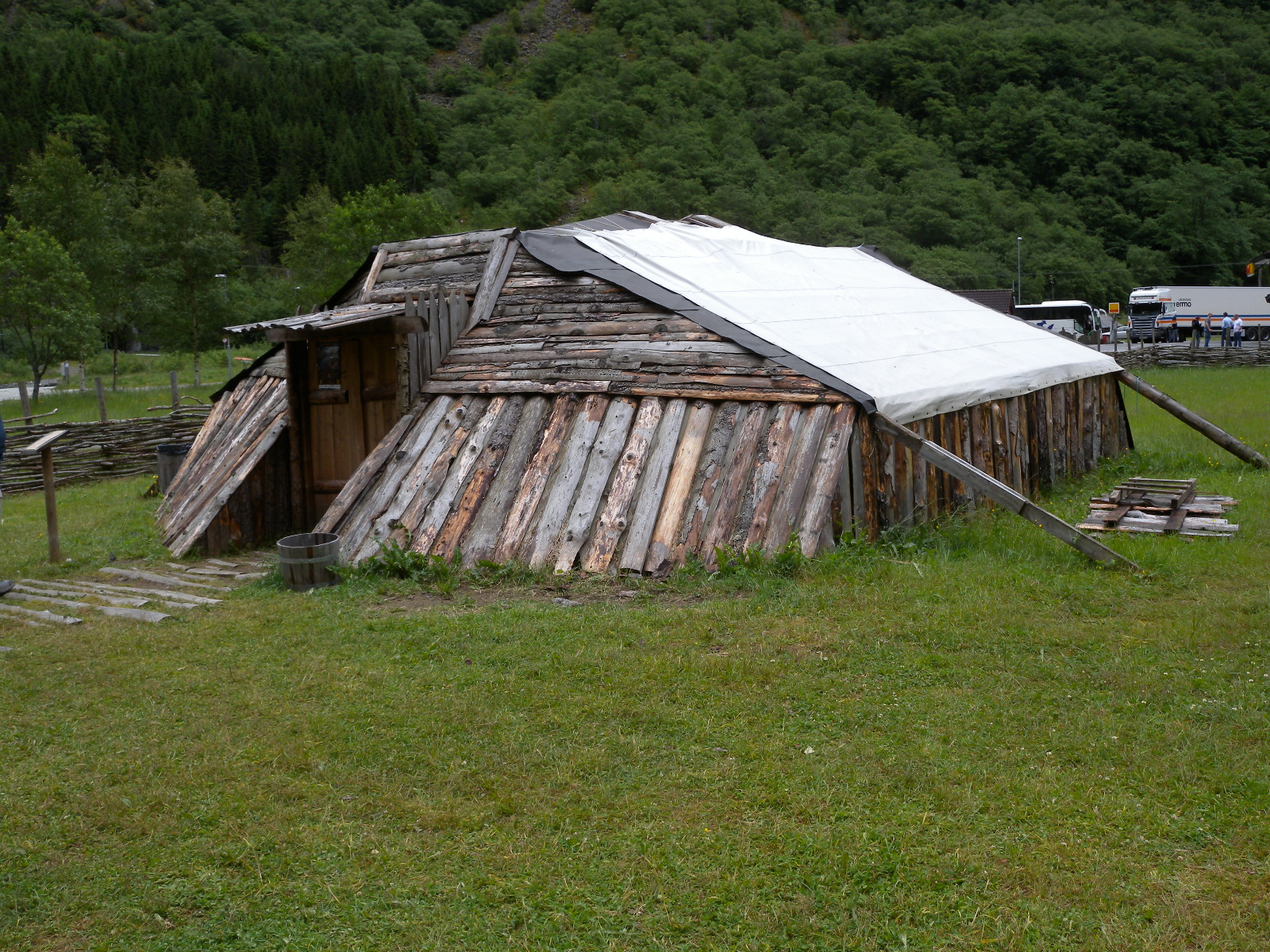 a small wooden structure sitting in the middle of a field