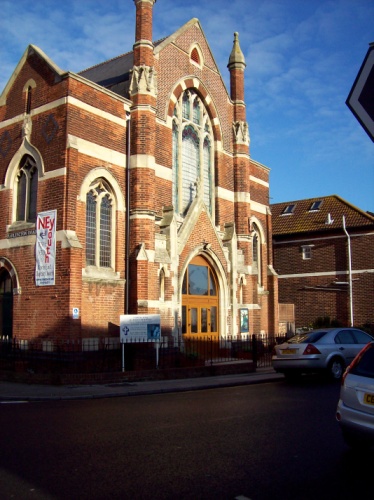 a large brick church with two towers is on the street
