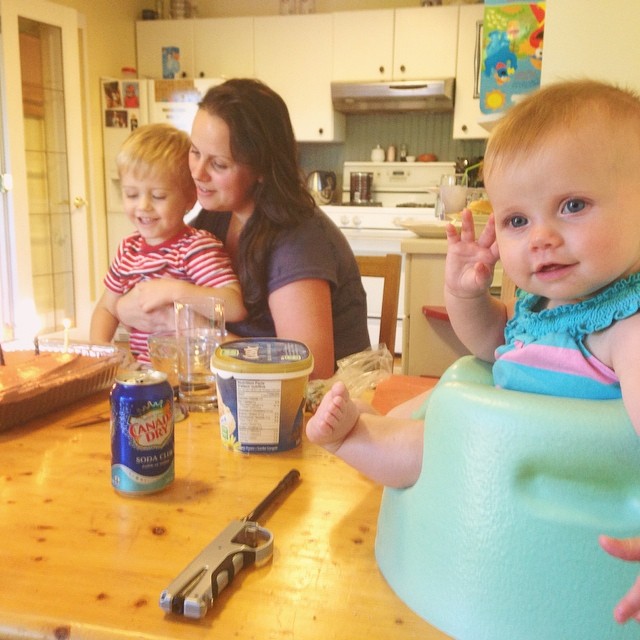 two adults and a child with two drinks in the kitchen