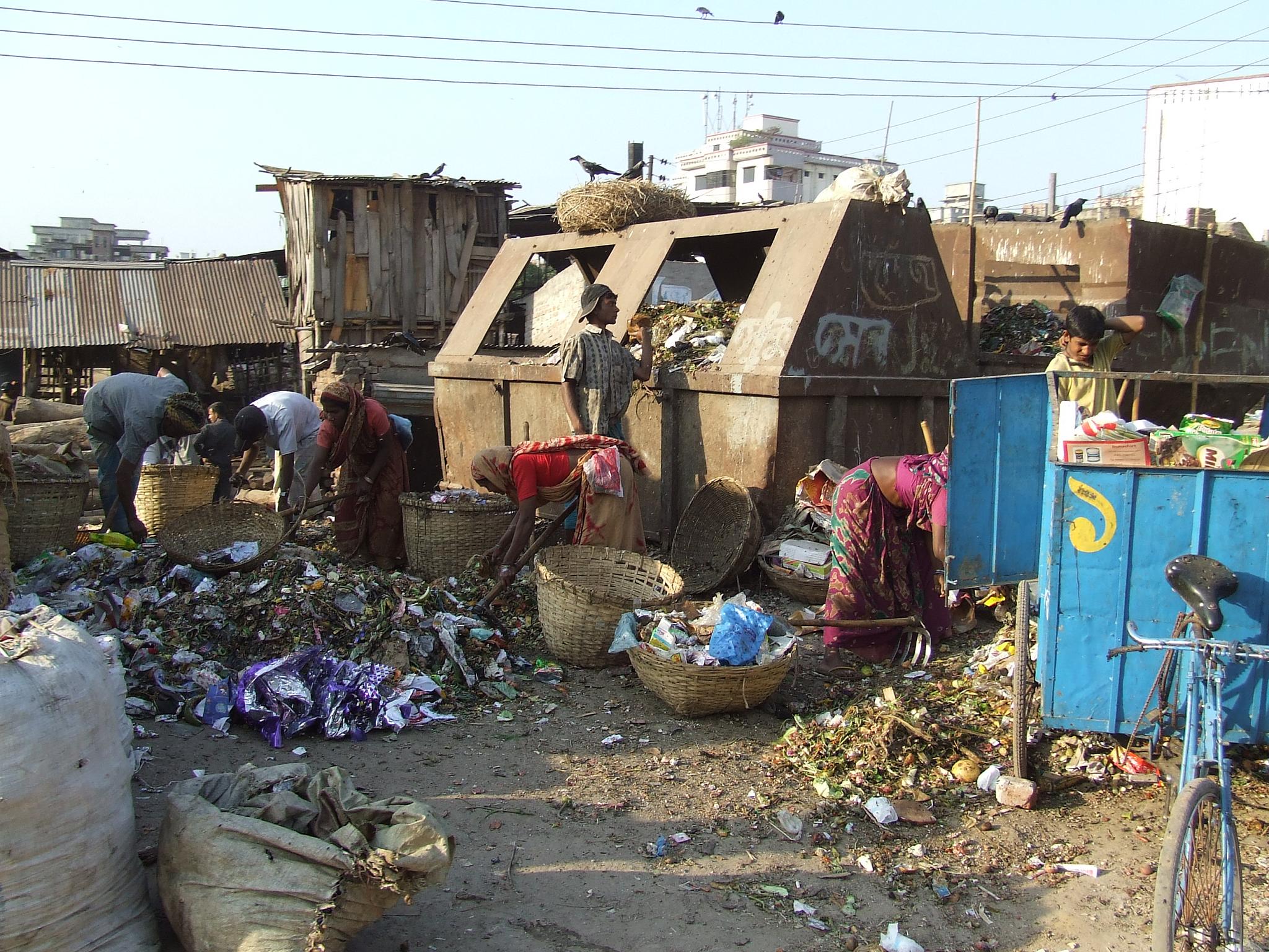 several people gathering around on top of garbage