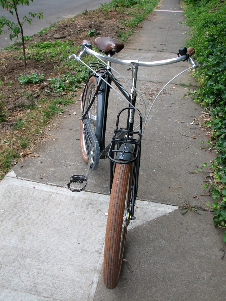 an old bicycle parked on the side of a cement path