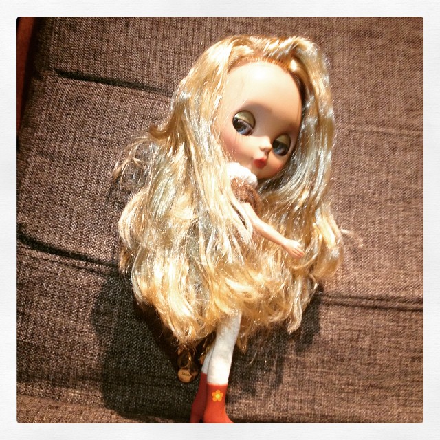 a doll lying on top of a brown couch